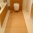 Συνδυασμός μαρμάρου και ξύλινου δαπέδου σε WC. To δάπεδο τοποθετήθηκε κολλητά σε τσιμεντοκονία.